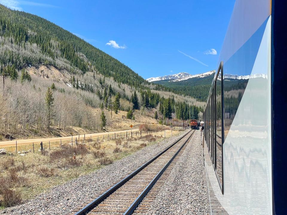 The Rocky Mountaineer waits for a freight train to pass by causing a delay.