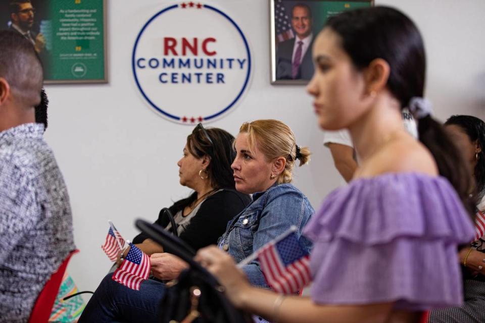 Maigrey Guerra Pérez, en el centro, escucha mientras el director de comunicaciones hispanas del Comité Nacional Republicano, Jaime Florez, se dirige a los graduados de un curso de civismo para migrantes que tomarán el examen de naturalización de Estados Unidos, en el Centro Comunitario Hispano del RNC, en Doral, Florida, el martes 4 de octubre de 2022.