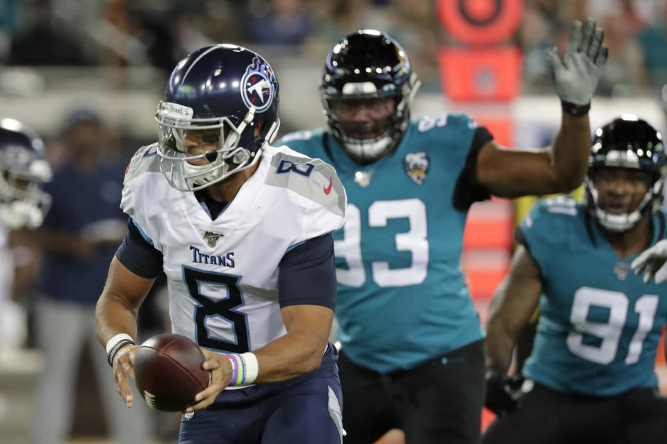 Tennessee Titans quarterback Marcus Mariota (8) looks to hand off the ball as he is pressured by Jacksonville Jaguars defensive end Calais Campbell, right, during the first half of an NFL football game, Thursday, Sept. 19, 2019, in Jacksonville, Fla. (AP Photo/John Raoux)