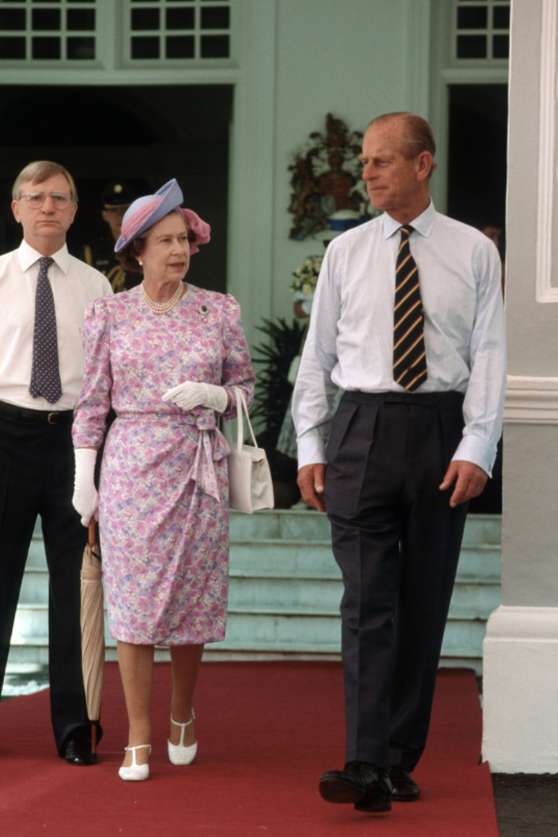 <p>Looking lovely in pink and lilac, this simple summer outfit must have kept the Queen cool during a tour of Singapore.<br><i>[Photo: Rex]</i> </p>