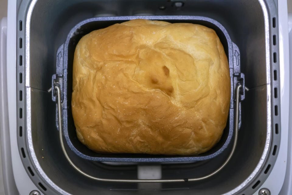 A freshly baked loaf of bread inside a bread-making machine