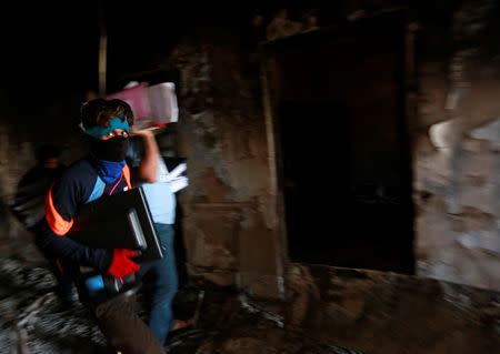 A worker holds the remaining files from the fire of the municipality building of Basra, Iraq September 6, 2018. REUTERS/Alaa al-Marjani