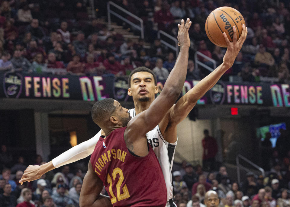 San Antonio Spurs' Victor Wembanyama (1) shoots over Cleveland Cavaliers' Tristan Thompson (12) during the first half of an NBA basketball game in Cleveland, Sunday, Jan. 7, 2024. (AP Photo/Phil Long)