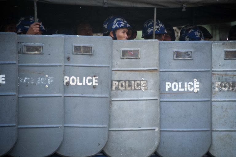 Police take position behind shields near Yangon City Hall after a crackdown on a peaceful demonstration supporting the student protests in Yangon on March 5, 2015