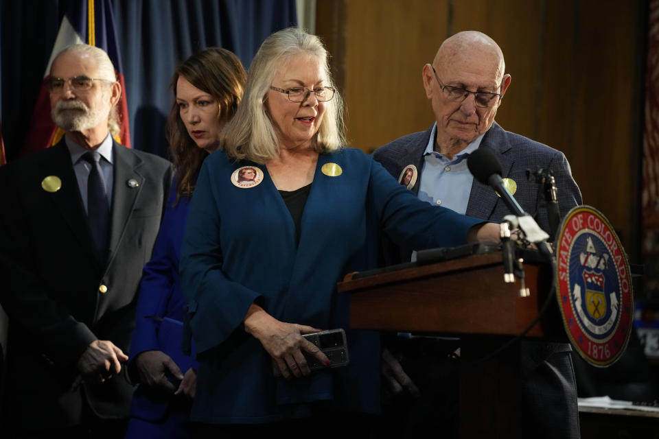 Sandy and Lonnie Phillips, who lost their daughter in the mass shooting at a theatre in Aurora, Colo., look on before Colorado Gov. Jared Polis signs four gun control bills into law during a ceremony, Friday, April 28, 2023, in the State Capitol in Denver. (AP Photo/David Zalubowski)