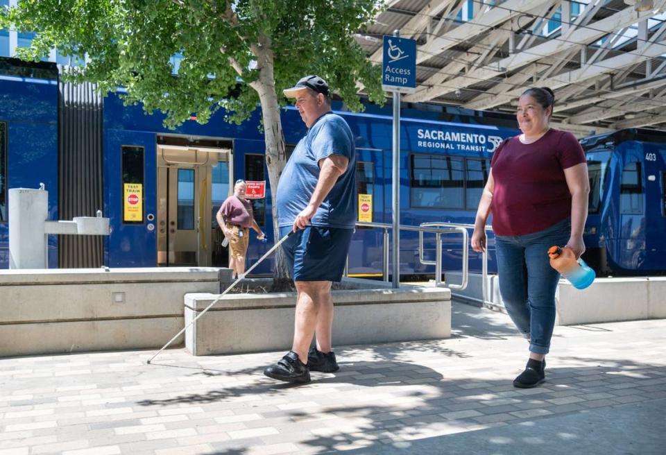 Rick Hodgkins, quien tiene discapacidad visual, y Alexandria Mendibles salen de un nuevo tren ligero de piso bajo S700 usando una rampa de acceso en la estación Township 9 de Sacramento, el miércoles. Mientras estaban dentro del tren, Hodgkins y Mendibles hablaron con un supervisor de mantenimiento del tren ligero de Sacramento Regional Transit para comprender mejor las diversas características de seguridad y accesibilidad del vehículo.