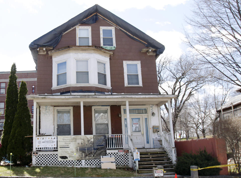 FILE - In this March 29, 2016, file photo, signs call attention to the house where slain African-American leader Malcolm X spent part of his childhood in the Roxbury neighborhood of Boston. According to the National Park Service the house was added to the National Register of Historic Places in February 2021. (AP Photo/Bill Sikes, File)