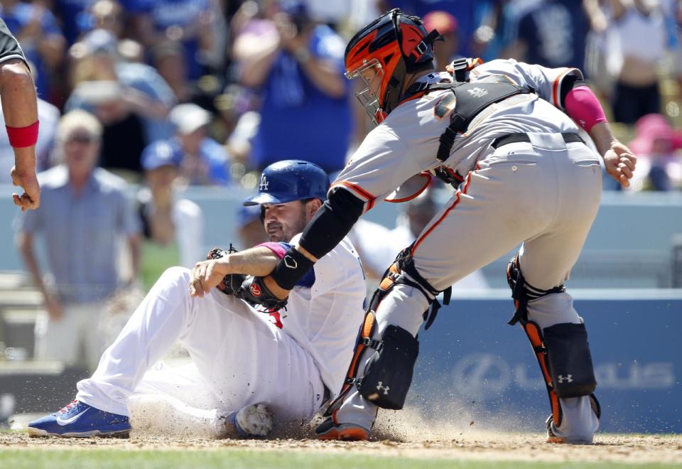 San Francisco Giants catcher Buster Posey, right, tags out Los Angeles Dodgers’ Adrian Gonzalez trying to score from second base on a single to center field in the sixth inning of a baseball game on Sunday, May 11, 2014, in Los Angeles. (AP Photo/Alex Gallardo)