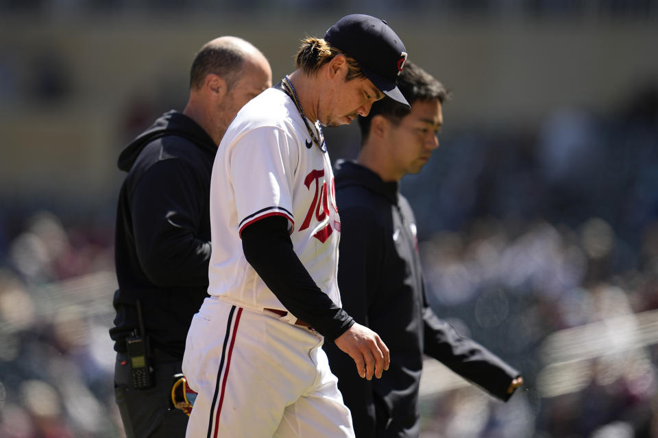 Minnesota Twins starting pitcher Kenta Maeda leaves the game with a trainer and translator during the fourth inning of a baseball game against the New York Yankees, Wednesday, April 26, 2023, in Minneapolis. (AP Photo/Abbie Parr)