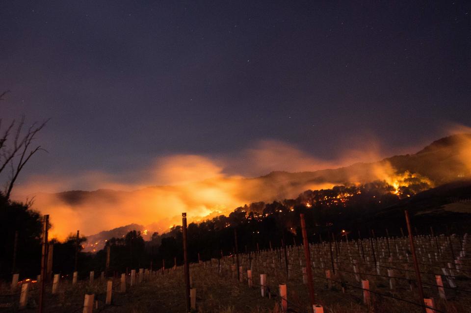 Fire glows on a hillside in Napa County, California, on Oct. 9, 2017, as multiple wind-driven blazes continue to whip through the region.