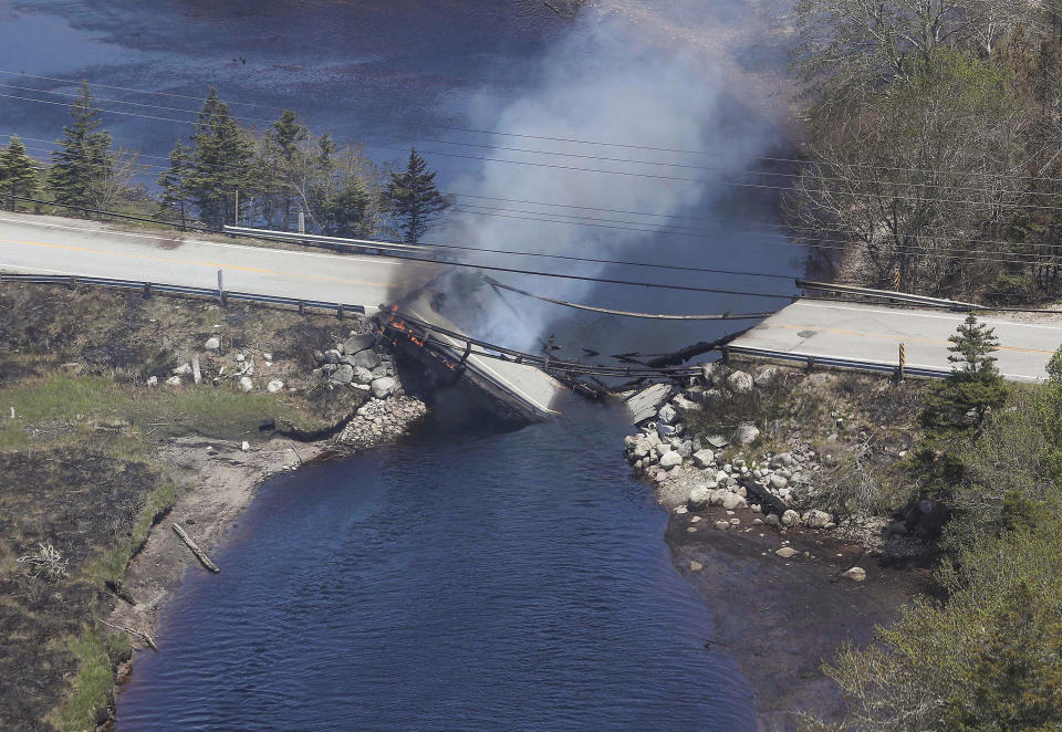 In this aerial image, collapsed bridge between the Clyde River and Port Clyde as wildfires burn in Nova Scotia, Wednesday, May 31, 2023 . (Communications Nova Scotia/The Canadian Press via AP)
