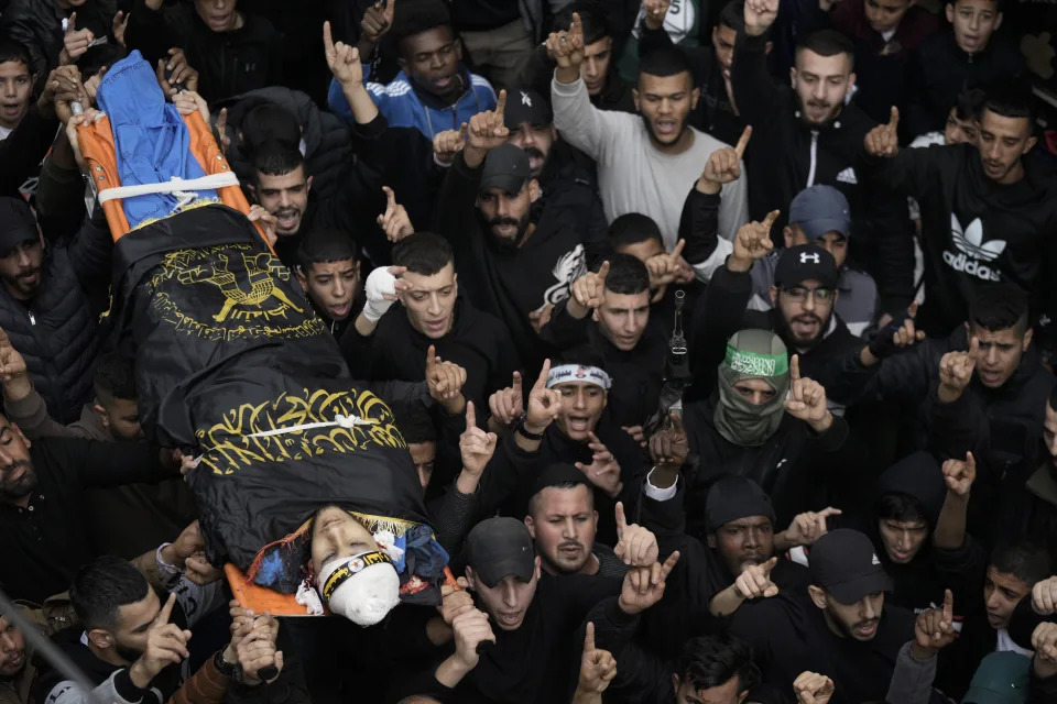 Mourners carry the body of Moaz Zahran, draped in the Islamic Jihad militant group flag during his funeral at Al-Far'a Camp, West Bank, Wednesday, Dec. 6, 2023. Palestinian health officials say that the Israeli military raided parts of the northern West Bank, sparking clashes with local militants that killed two Palestinians. (AP Photo/Majdi Mohammed)