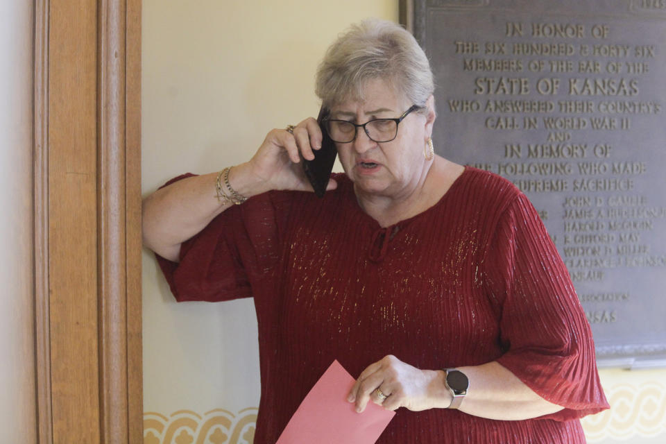 Kansas House Health Committee Chair Brenda Landwehr, R-Wichita, talks on the phone with GOP colleagues outside a caucus meeting and ahead of a vote on a proposed "born alive infants protection" law, Tuesday, April 4, 2023, at the Statehouse in Topeka, Kan. Under the measure, doctors could face lawsuits and criminal charges over allegations of not providing reasonable medical care for infants born during abortion procedures. (AP Photo/John Hanna)