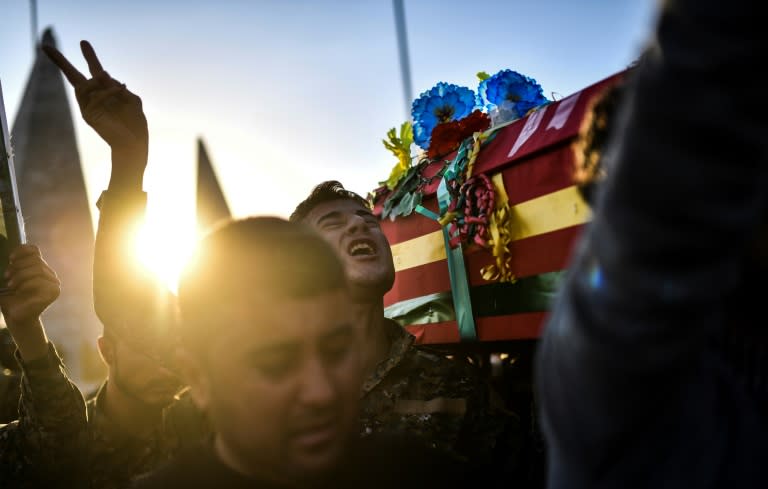 Kurdish militiamen carry the coffin of a fighter killed battling the Islamic State group in eastern Syria, at a funeral in Kobane on October 14, 2017