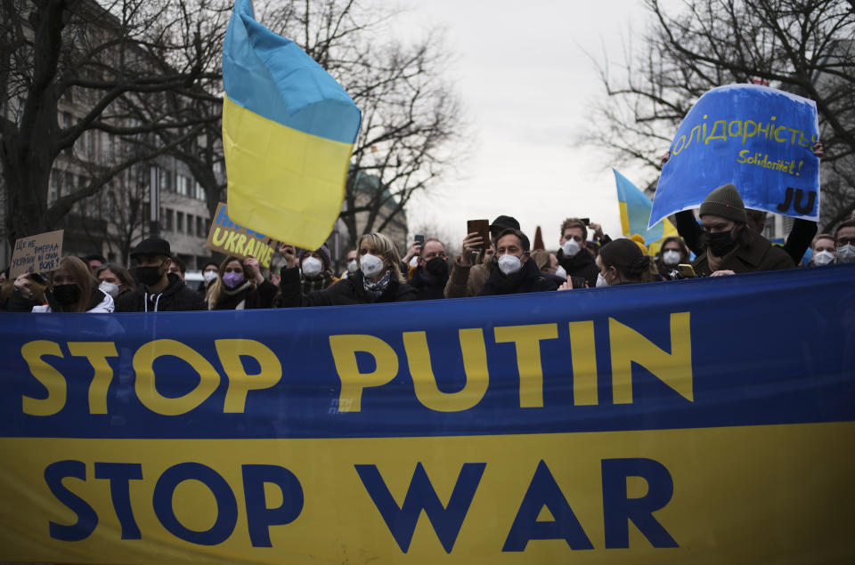 Demonstrators stand along the street near the Russian embassy to protest against the escalation of the tension between Russia and Ukraine in Berlin, Germany, Tuesday, Feb. 22, 2022. Russian President Vladimir Putin has asked the country’s parliament for permission to use military force outside the country. That could presage a broader attack on Ukraine after the U.S. said an invasion was already underway there. Poster right reads:'Solidarity'. (AP Photo/Markus Schreiber)