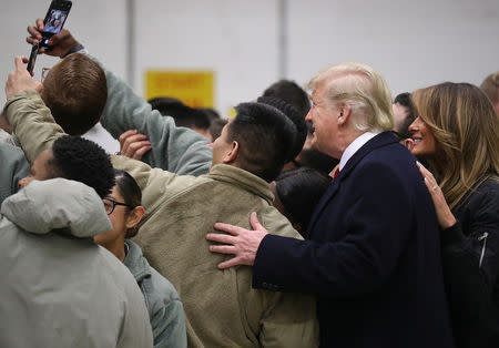 U.S. President Donald Trump and first lady Melania Trump take a selfie with U.S. troops at Ramstein Air Force Base, Germany, December 27, 2018. REUTERS/Jonathan Ernst