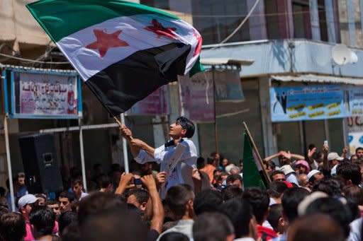 A Syrian youth waves the Syrian revolutionary flag during an anti-government demonstration after Friday prayers in the rebel-controlled northern countryside city of Mareh. Russia reported finding agreement with the United States on Syria and voiced optimism that crucial Geneva talks Saturday could bring a shift toward peace after 16 months of bloodshed