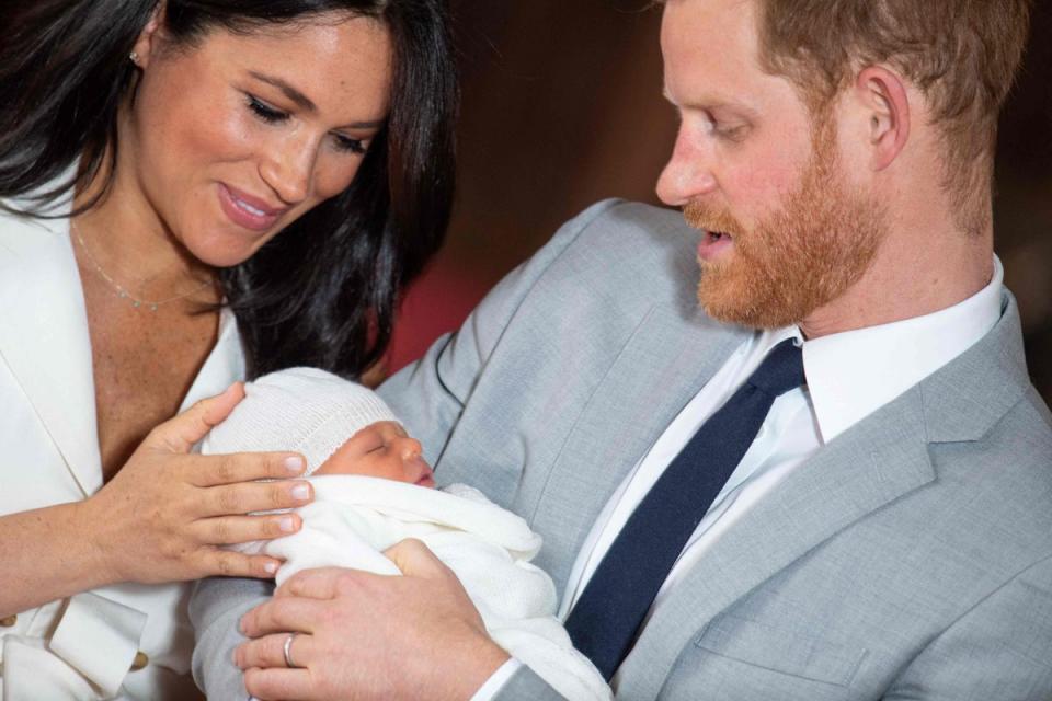 Prince Harry, Duke of Sussex (R), and his wife Meghan, Duchess of Sussex, pose for a photo with their newborn baby son, Archie Harrison Mountbatten-Windsor, in St George’s Hall at Windsor Castle in Windsor, west of London on May 8, 2019 (POOL/AFP via Getty Images)