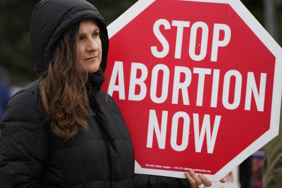 FILE - Kinga Gebauer holds a sign in front of the Walgreens corporate headquarters during a protest over plan to sell abortion pills Walgreens Deerfield Headquarters in Deerfield, Ill., Tuesday, Feb. 14, 2023. One year ago, the U.S. Supreme Court rescinded a five-decade-old right to abortion, prompting a seismic shift in debates about politics, values, freedom and fairness. (AP Photo/Nam Y. Huh, File)