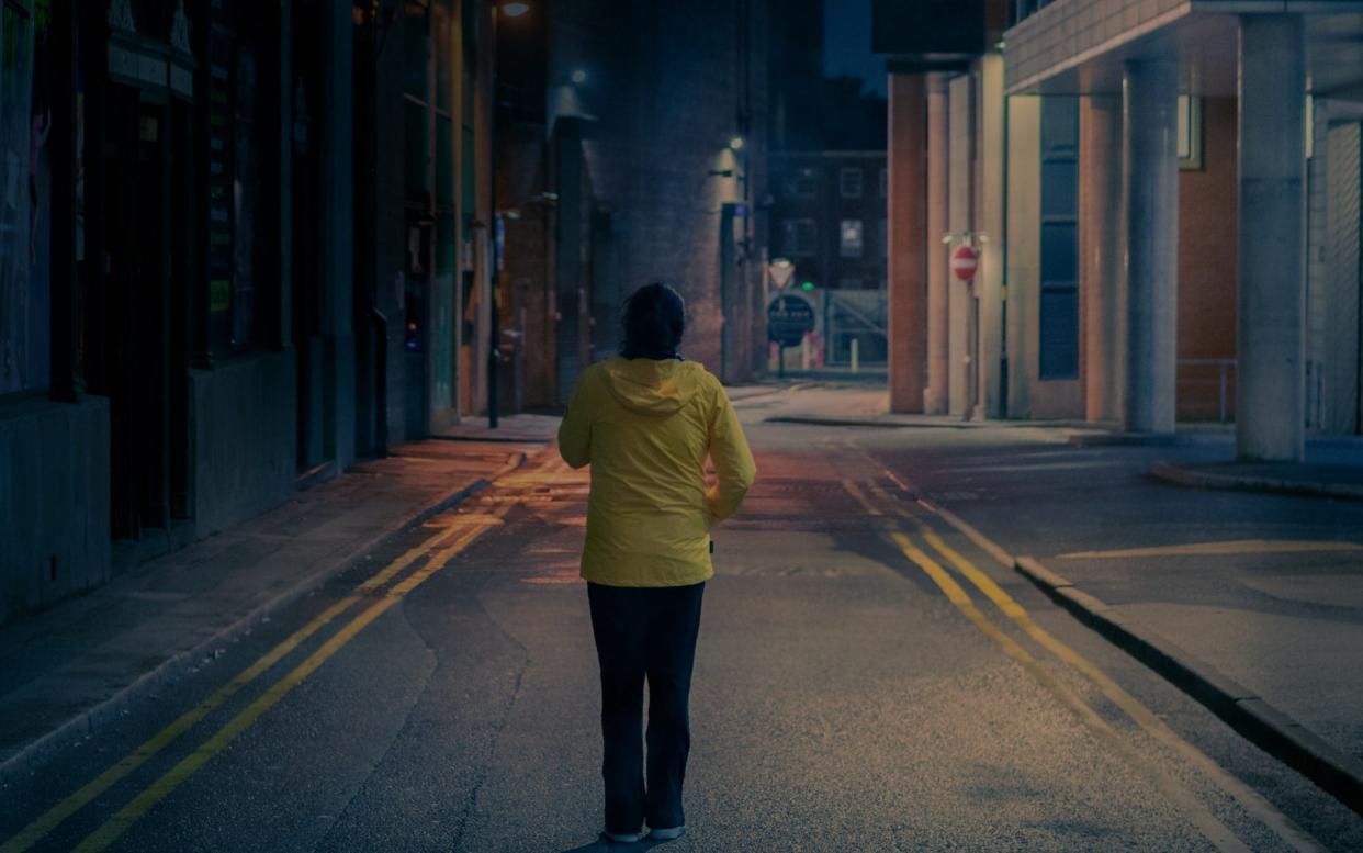 A woman walking on the street at night - EyeEm