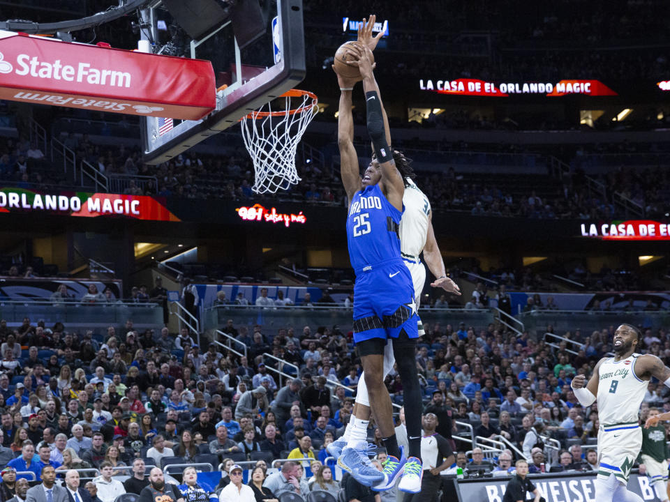 Orlando Magic forward Wes Iwundu (25) slams the ball on Milwaukee Bucks forward Giannis Antetokounmpo during the first half of an NBA basketball game in, Orlando, Fla., Saturday, Feb. 8, 2020. (AP Photo/Willie J. Allen Jr.)