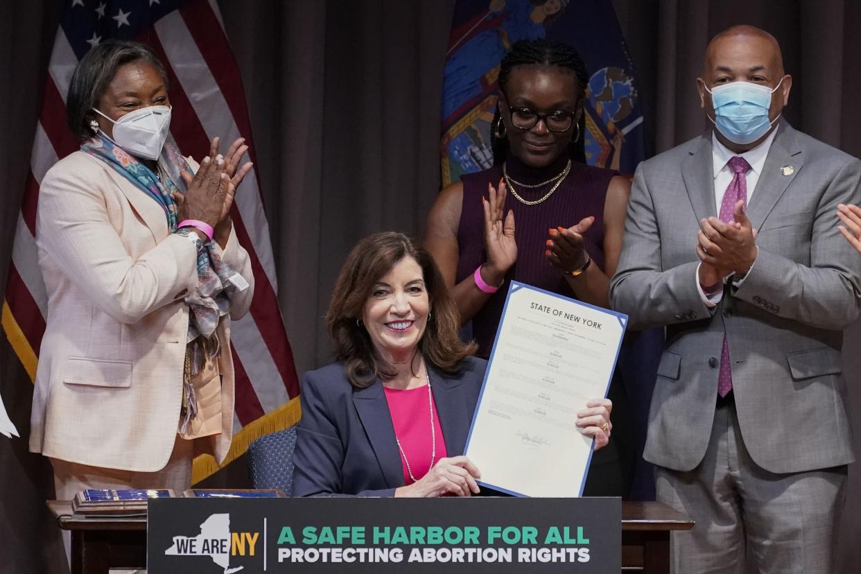 New York Gov. Kathy Hochul, center, poses for photos after signing a legislative package to protect abortion rights during a ceremony in New York, Monday, June 13, 2022. New York has expanded legal protections for people seeking and providing abortions in the state under legislation signed by Gov. Hochul on Monday. 