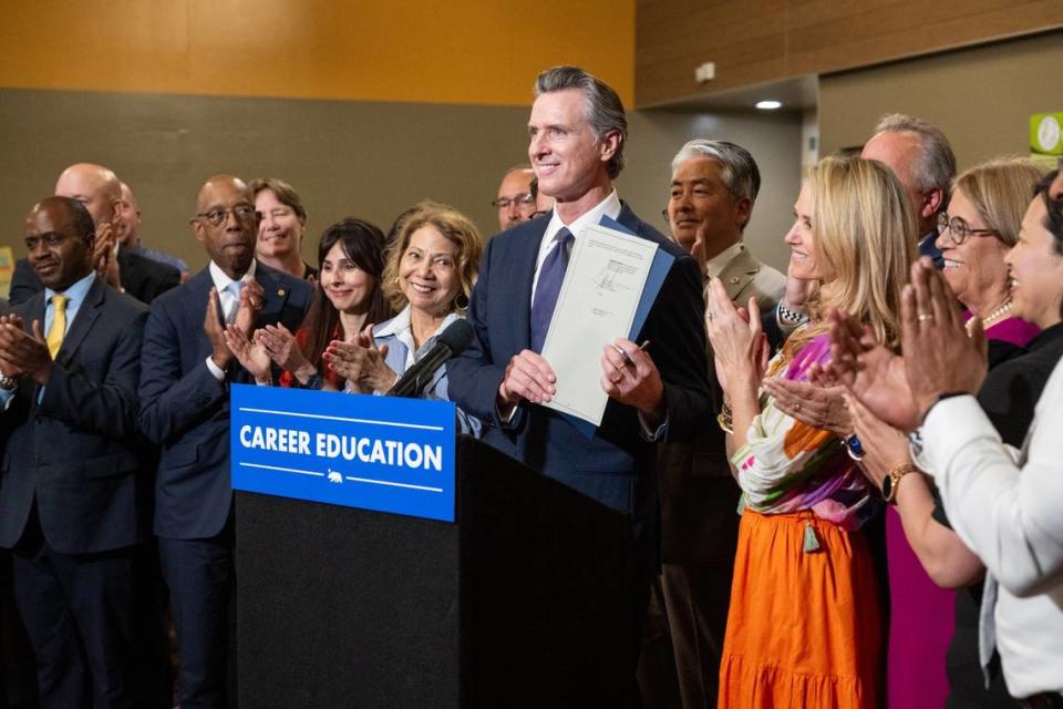 California Gov. Gavin Newsom, joined by First Partner Jennifer Siebel Newsom and public education and workforce leaders, presents the signed executive order on education at River City High School in West Sacramento on Thursday. Paul Kitagaki Jr./pkitagaki@sacbee.com