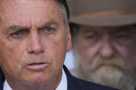 Brazil's President Jair Bolsonaro, who is running for reelection, speaks in front of one of the leaders of the ruralist parliamentary bench, Deputy Nelson Ned, during a meeting with political allies ahead of the second round of presidential elections at the presidential residence, Alvorada palace, in Brasilia, Brazil, Wednesday, Oct. 5, 2022. The run-off is set for Oct. 30. (AP Photo/Eraldo Peres)