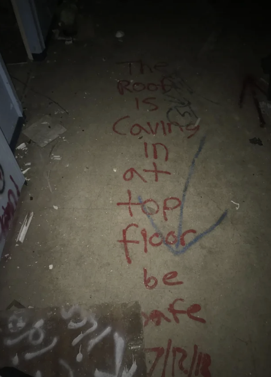 A message drawn on the floor says "the roof is caving in at the top floor, be safe"