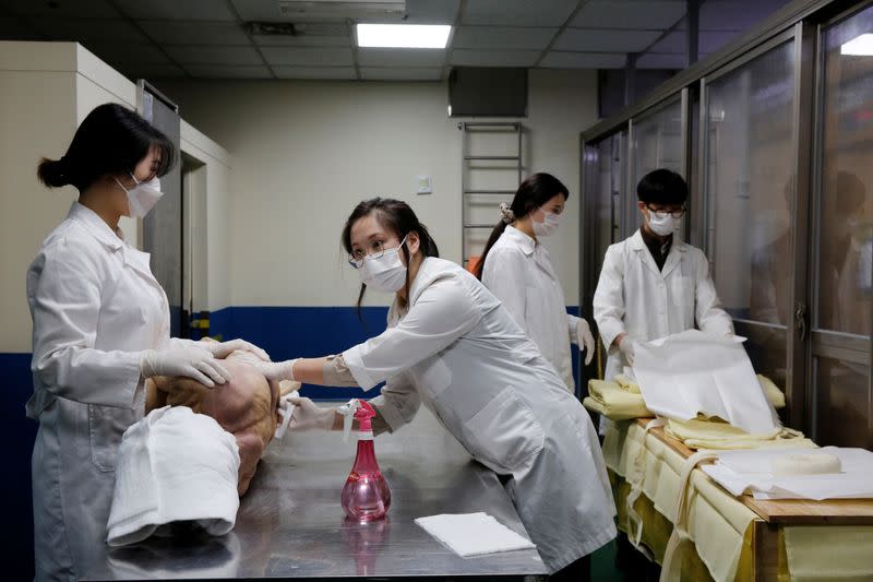 Park Bo-ram, a funeral director, cleans the body of a deceased at a funeral home in a medical center in Seoul