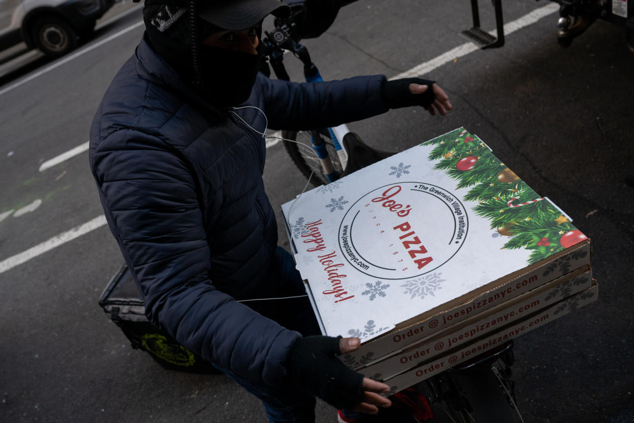 NEW YORK, NEW YORK - DECEMBER 09: A delivery person handles Joe's Pizza holiday boxes near Times Square on December 09, 2022 in New York City. (Photo by Alexi Rosenfeld/Getty Images)