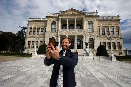 Naz Osmanoglu, a British comedian and member of Turkey's former ruling family, poses at the entrance of the Ottoman-era Dolmabahce Palace in Istanbul, Turkey, October 19, 2016. REUTERS/Osman Orsal