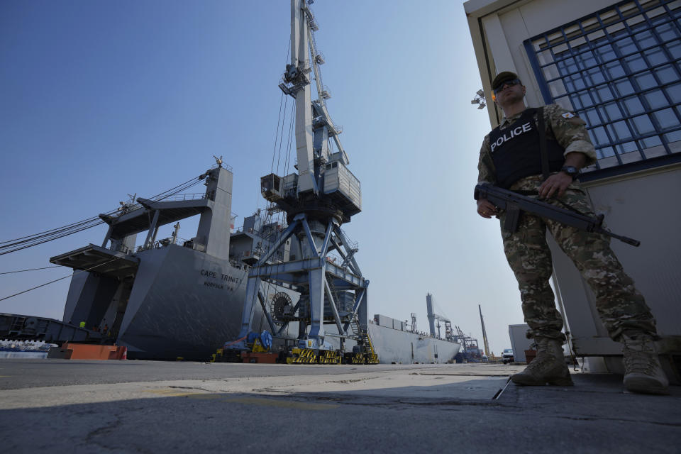 A Cypriot military police officer stands guards next of the docked U.S ship carrying Gaza aid, at the port of Larnaca, Cyprus, Wednesday, June 26, 2024. An official with the U.S. humanitarian assistance agency USAID says thousands of tons of food, medicines and other aid piled up on a Gaza beach isn't reaching those in need because of a dire security situation on the ground where truck drivers are either getting caught in the crossfire or have their cargo seized by "gang-like" groups. (AP Photo/Petros Karadjias)