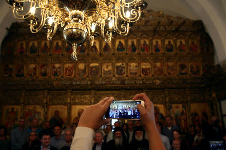 A pilgrim takes a picture inside the Church of the Monastery of Apostolos Andreas in north-eastern Cyprus after the structure was reopened after two years of renovation, Cyprus November 7, 2016. REUTERS/Yiannis Kourtoglou