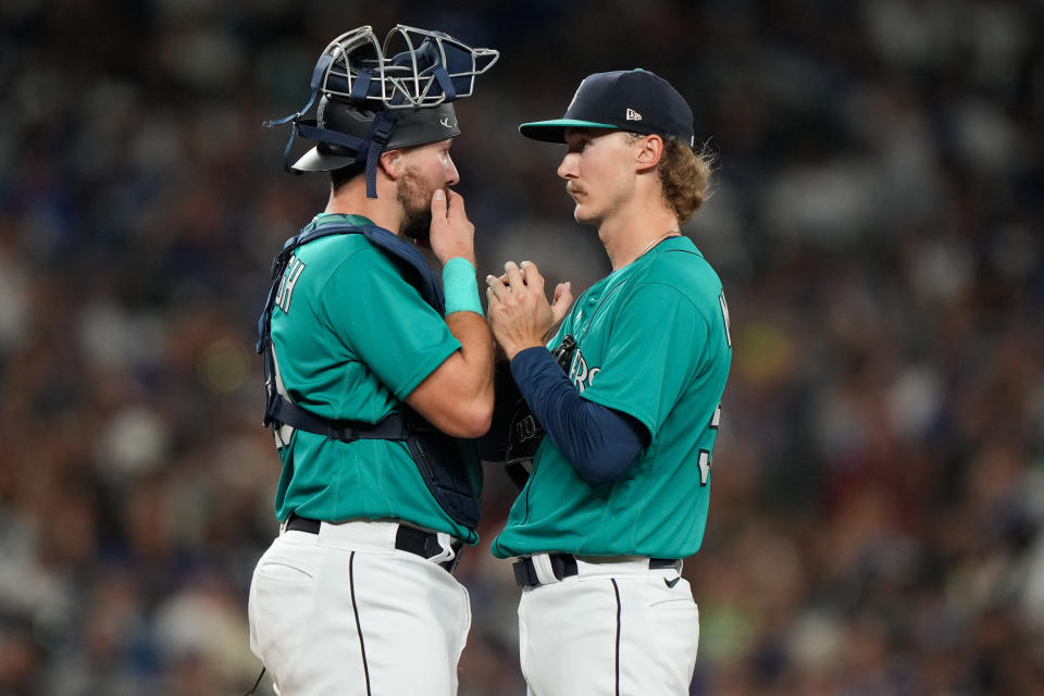 The Seattle Mariners ask a lot of of catchers such as Cal Raleigh (left) in relaying key information and guidance to pitchers such as Bryce Miller (right). (Liv Lyons/MLB Photos via Getty Images)