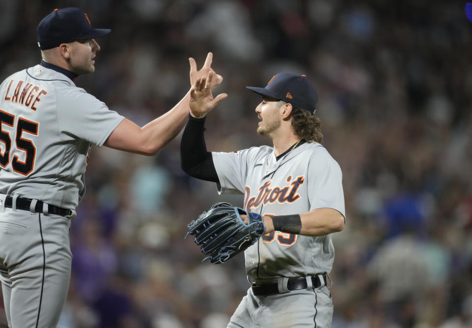Detroit Tigers relief pitcher Alex Lange, left, and left fielder Zach McKinstry share congratulations after hte team's win over the Colorado Rockies in 10 innings in a baseball game Saturday, July 1, 2023, in Denver. (AP Photo/David Zalubowski)