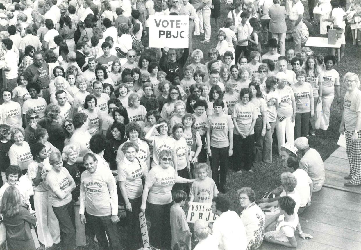 A crowd, including Dr. Edward M. Eissey, then-president of Palm Beach Junior College, urges the community to vote in favor of a half-mill property tax increase to improve the college's aging facilities during the 1980s.