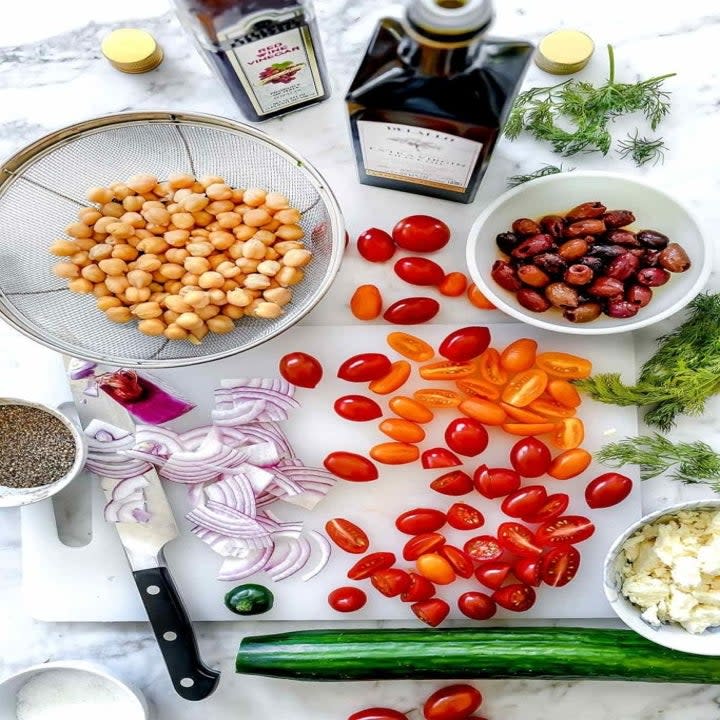 Chickpeas, tomatoes, cucumber, onion, and more ingredients for salad.