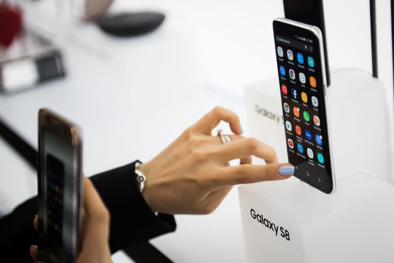 An attendee views the Samsung Electronics Co. Galaxy S8 smartphone displayed during the Samsung Unpacked product launch event in New York, U.S., on Wednesday, March 29, 2017. Samsung Electronics Co. packed the Galaxy S8 smartphone with a plethora of new features: taller, curved screens, encrypted facial recognition, deeper display colors, system-wide voice control and the ability to turn into a desktop computer. Photographer: Mark Kauzlarich/Bloomberg