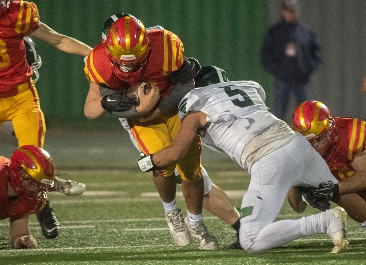 Oakdale's Brian Delte, left, is tackled by Manteca's Alijah Cota during the Sac-Joaquin Section Division III championship game at St. Mary's High School in Stockton. Manteca won 35-28.