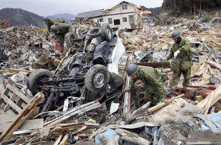 Members of Japan's Self Defense Force search for survivors in an area hit by an earthquake and tsunami in Rikuzentakata, Iwate prefecture March 15, 2011 file photo. REUTERS/Toru Hanai/Files