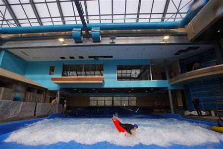 Dan Burke, 2007 C1 freestyle kayak world champion, tests the waves in a kayak at the still under-construction Surf's Up indoor water and surf park in Nashua, New Hampshire November 15, 2013. REUTERS/Brian Snyder