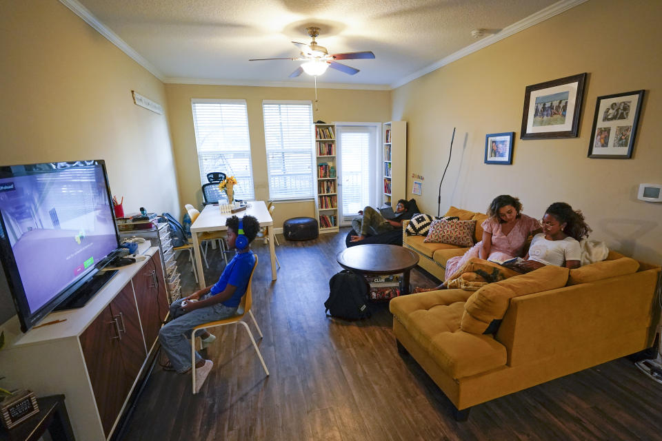 Jessy Correa, second from right, with Genesis Cross, right, Chronicles Cross, back center, and Jerusalem, left, at their apartment Monday, Oct. 24, 2022, in Ocoee, Fla. Correa supports a ballot initiative in Orange County that would limit annual rent increases to the annual increase in the consumer price index. (AP Photo/John Raoux)