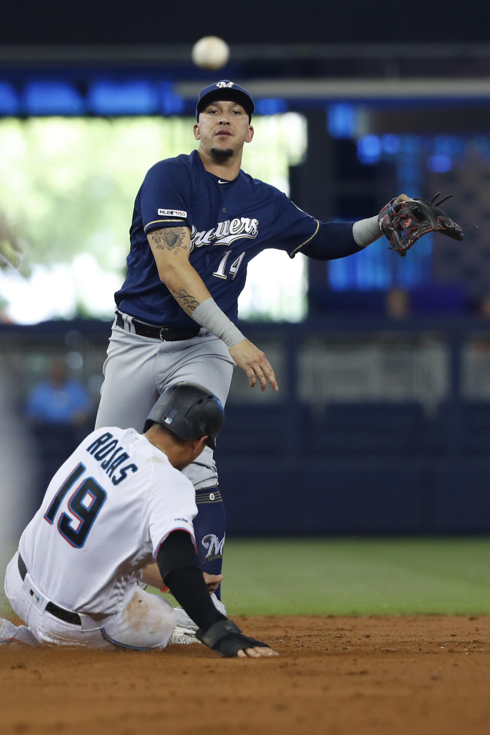 Milwaukee Brewers second baseman Hernan Perez (14) throws to first to attempt the double play after putting out Miami Marlins' Miguel Rojas (19) at second base during the third inning of a baseball game, Thursday, Sept. 12, 2019, in Miami. Starlin Castro was safe at first base. (AP Photo/Wilfredo Lee)