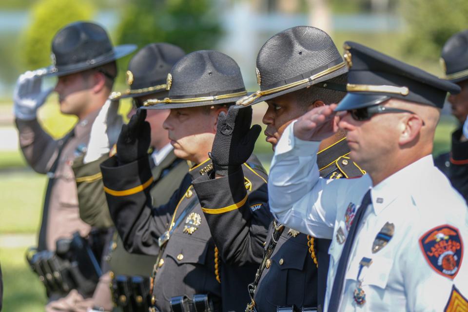 Officers salute during the National Anthem at the 34th annual Polk County Peace Officer Memorial service Thursday.