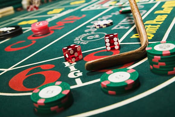 Dice on craps table with chips and the croupier stick collecting the dice.