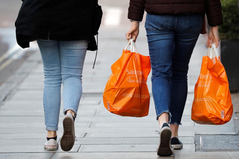 Shoppers carry their purchases in orange plastic Sainsbury's supermarket store shopping bags (Photo: Tolga AKMEN / AFP)