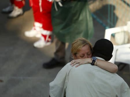 A migrant and the Medecins Sans Frontiere (MSF) team leader embrace as migrants disembark from the MSF rescue ship Bourbon Argos in Trapani, on the island of Sicily, Italy, August 9, 2015. REUTERS/Darrin Zammit Lupi MALTA OUT