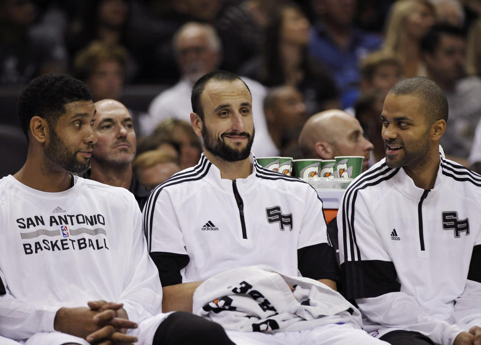 FILE - San Antonio Spurs' Tim Duncan, left, Manu Ginobili, center, and Tony Parker talk on the bench during the first half of a preseason NBA basketball game against the Miami Heat, Saturday, Oct. 18, 2014, in San Antonio. Ginobili is one of the headliners for Saturday night’s enshrinement ceremony in Springfield, Massachusetts. Ginobili spent all 16 of his NBA seasons in San Antonio, partnering with Tim Duncan and Tony Parker to form a Big Three that is, and surely will remain, one of the best trios the league has ever seen. (AP Photo/Darren Abate, File)