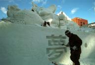 Japan's Ground Self-Defense members create a snow sculpture in preparation for the Snow Festival in Sapporo, northern Japan. About 2.2 million tourists visited the week-long winter festival, which displayed approximately 326 snow and ice sculptures.